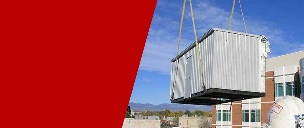 A custom KABTech sound enclosure lifted by crane to be placed in a facility