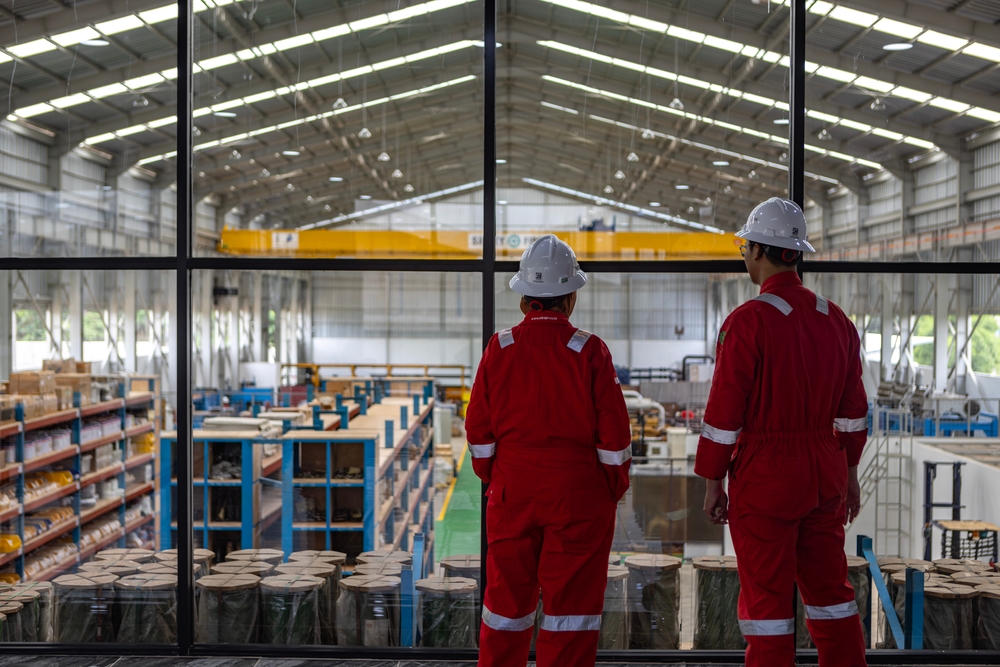 Two workers monitoring production from a mezzanine platform