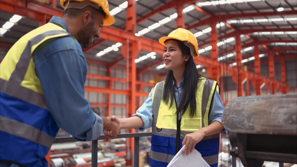 Contractors shaking hands while moving forward on a mezzanine system installation project