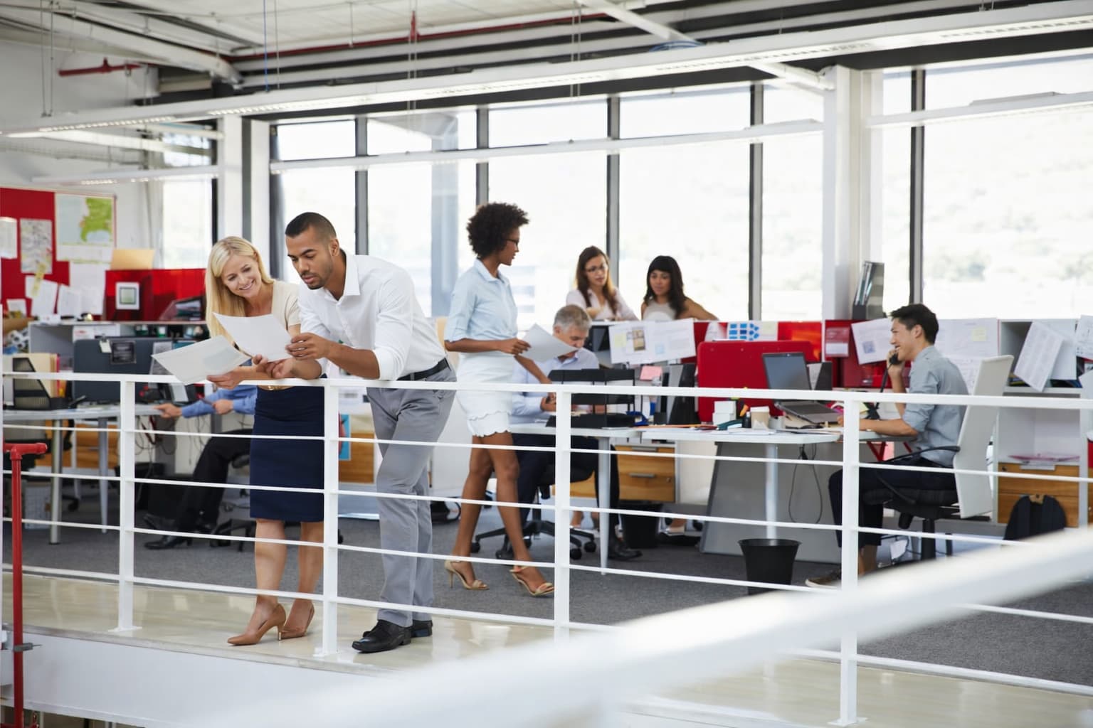 A group of employees working on the top level of a mezzanine