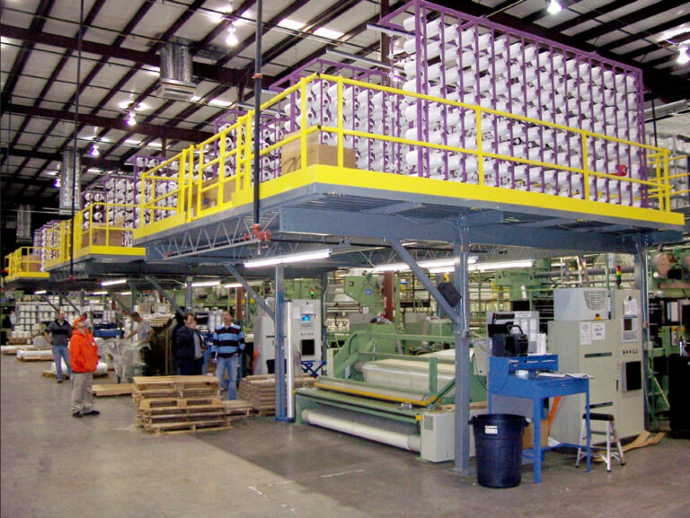 A storage mezzanine with workers underneath and materials stored on the upper level