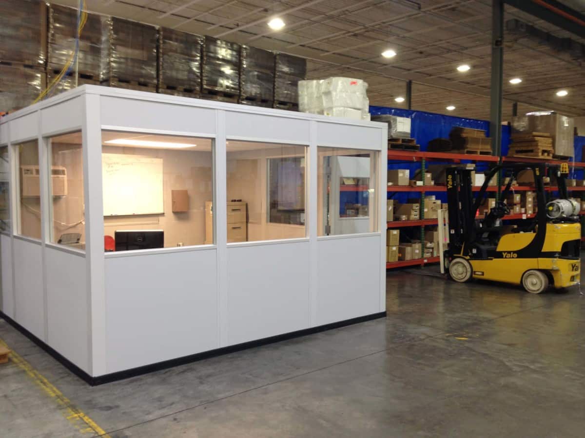 Prefabricated Shipping Office Placed Beside Palette Storage in a Warehouse