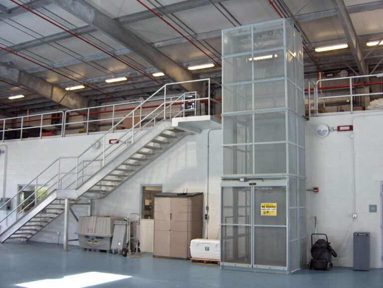 Yellow steel mezzanine and vertical material lift over plant equipment